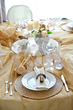 Detail of a table set in ocher color organza for a wedding banquet