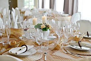 Detail of a table set in ocher color organza for a wedding banquet