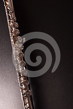 Detail of tansverse flute on black table vertical top