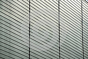 Detail or texture shot side of building facade and slatted wood pannels on exterior of black gray building in the