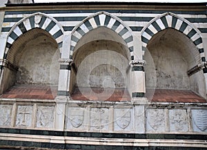 Detail with three niches, of the beautiful facade covered in white marble with black marble outline, of the church of Santa Maria