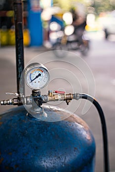 Detail of tire Inflator in gas station, old air pressure tank with guage and valve used to put air into the tire