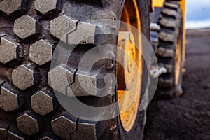 Detail on tire track pattern on a yellow heavy duty digger excavator