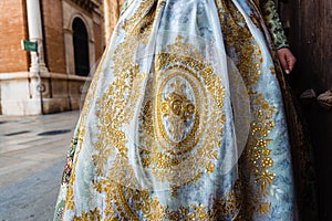 Detail of the traditional fallera dress, with rich golden thread embroidery on a silk skirt photo