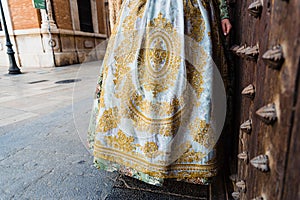 Detail of the traditional fallera dress, with rich golden thread embroidery on a silk skirt photo