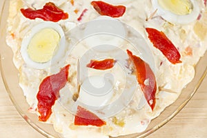 Detail of tray of Olivier salad (also known as Russian salad) covered by mayonnaise