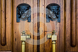 Sphinx heads entrance on wooden door