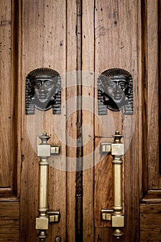 Sphinx heads entrance on wooden door