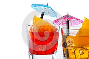 Detail of two cocktail with orange slice and umbrella on top isolated on white background