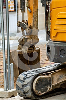 Detail of the undercarriage of a caterpillar tractor excavator that and the shovel to extract earth from the ground of a city