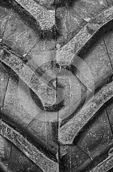 Detail up close of a tire tread from a tractor or other heavy duty construction machinery.