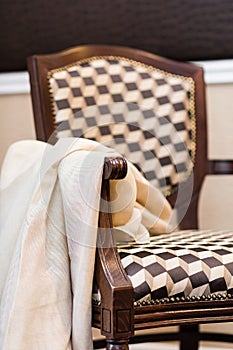 Detail of upholstered stylish wooden chair in brown/beige