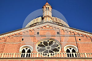 Detail of the upper part of the facade of the Basilica of Sant`Antonio in Padua with a large rose window and blue sky.