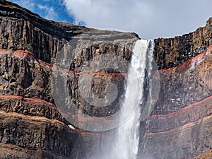 Detail of the upper part of waterfall Hengifoss with colored cliff in eastern Iceland