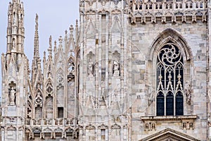 Detail of upper section of the Duomo di Milano populated with statuary