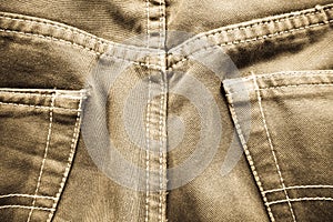 Detail from an used brown jeans, vintage effect