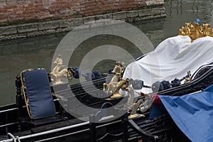 Detail of Venetian gondola in green canal waters of Venice Italy