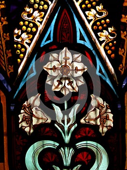 Detail of Victorian stained glass window showing white flower and decorative detail