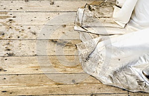 Detail view of beautiful white wedding dress train after outdoor wedding in rainy day on wooden board background.