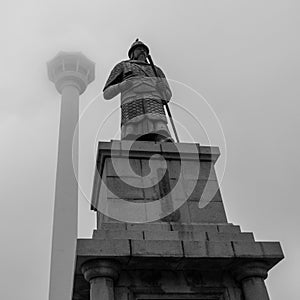 Detail view of Busan Tower and Statue of Admiral Yi Sun-sin in front on a foggy day. Jung-gu, Busan, South Korea. Asia