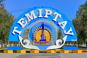 Detail View of the colorful Emblem and Flag of City Temirtau on the End of the main Promenade. Outgoing Street with many Threes to