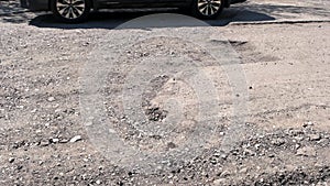 Detail view of damaged road with big potholes.