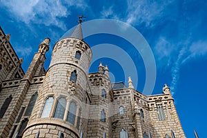 Detail view of Episcopal palace in Astorga, landmark of architect Antoni Gaudi, with tower against clear blue sky