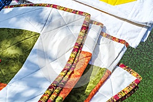 Detail View Of  folded Quilts On a grass,