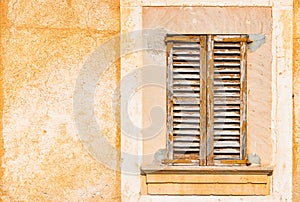 Old brown wood window shutter with rusti plaster wall background