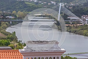 Detail view of traditional chimney, with blurred Mondego river and Rainha Santa Isabel Bridge as background in Coimbra, Portugal photo