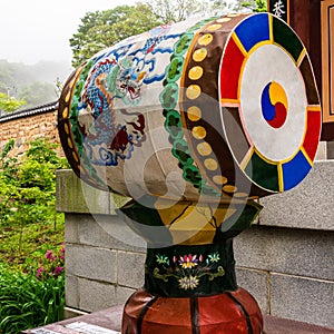 Detail view on a traditional drum, barrel in the Korean Buddhistic Temple Beomeosa on a foggy day. Located in Geumjeong, Busan,