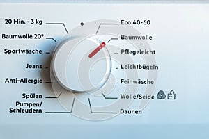 Detail view of washing machine control panel with contemporary thermostat and program selection to switch between different progra