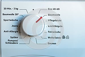 Detail view of washing machine control panel with contemporary thermostat and program selection to switch between different progra