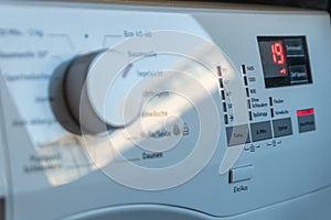 Detail view of washing machine control panel with contemporary thermostat and program selection to switch between different progra