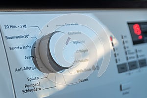Detail view of washing machine control panel with contemporary thermostat and program selection to switch between different progra