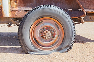 Detail of a vintage abandoned flat car tire on the side of a road