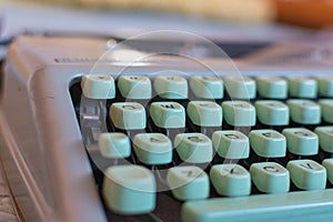 Detail of a vintage typewriter with mint green keys and shallow depth of field