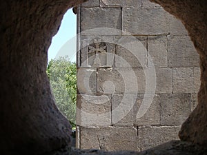 Graven Armenian cross seen by a stone window, Armenia. photo