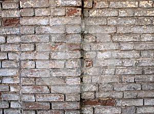 Detail of a wall of an old red brick with white coating