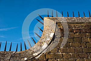 Detail of wall with row of sharp spikes along edge