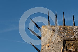 Detail of wall with row of sharp spikes along edge