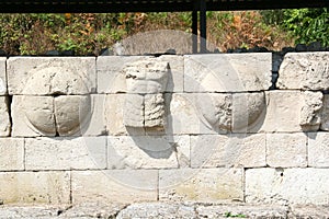 Detail of a wall of shields and torsos along the main road Dion