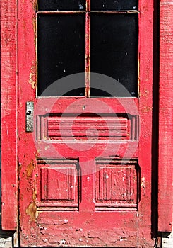 DEtail of weathered Red door with peeling paint