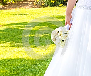 Detail of wedding bouquet of flowers in hand of a bride in a garden