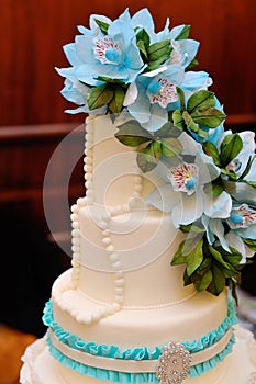 Detail of wedding cake with blue flowers