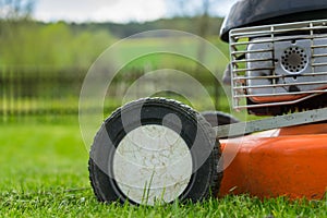 Detail of wheel and piece of motor of lawn mower (grass cutter)