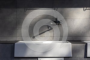 Detail of white ceramic sink for washing clothes under a canopy in a campsite