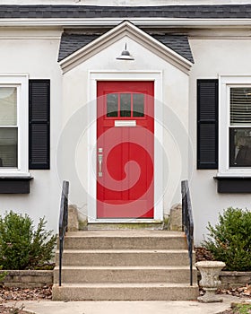 A detail of a white home s red front door.