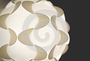 Detail of a white illuminated puzzle lamp from the sixties