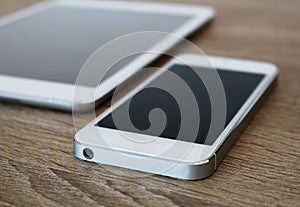 Detail of white mobile phone and white tablet